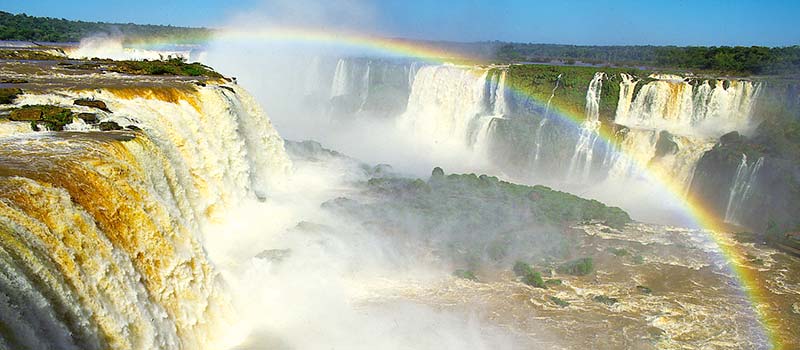 Im feinen Wasserdunst der Wasserfälle von Iguaçu reflektieren sich Regenbogen